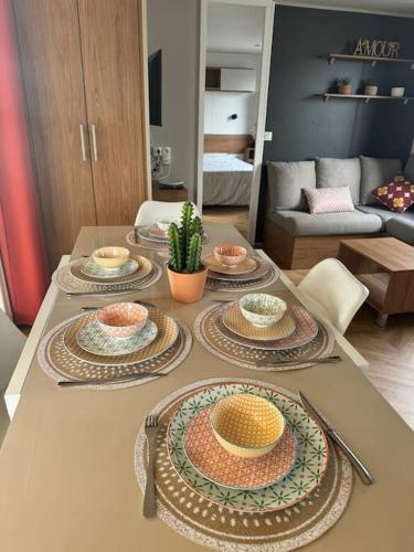 a table with plates of food on it in a living room at Mobile Home 450 4-6 pers Camping Siblu Le Lac des Rêves in Lattes