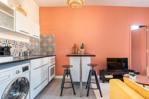 une cuisine avec un lave-linge et des tabourets dans l'établissement Appartement Endoume, à Marseille