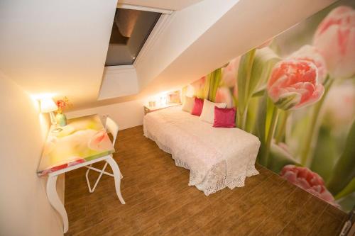 a room with two beds and a painting of flowers at Angel's Nest Apartment in Komenda