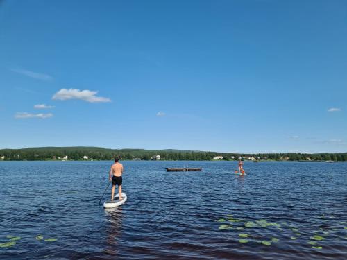 a man on a paddle board in the water at Björnbyn Stugby in Råda