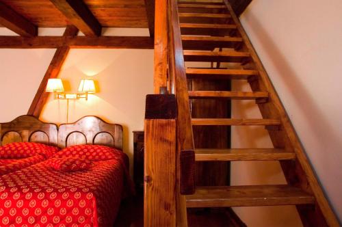 a bedroom with a red bed and a wooden staircase at Casa Wagner in Braşov