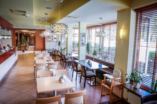 un ristorante con tavoli, sedie e finestre di Eden a Rydzyna