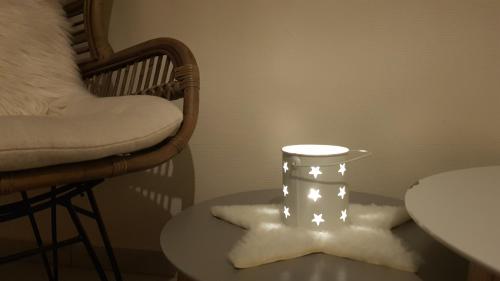 a table with a light on it next to a chair at Hostellerie Les Bagenelles in Sainte-Marie-aux-Mines