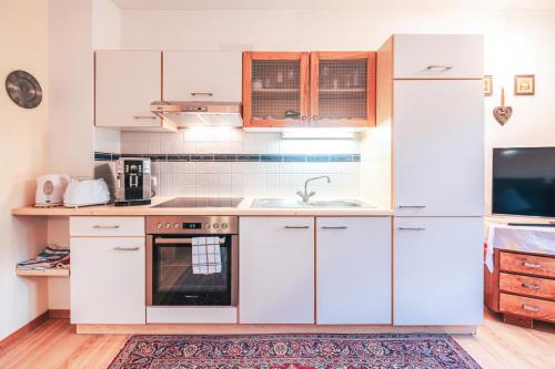 a kitchen with white cabinets and a sink at Haus Sandra in Kitzbühel
