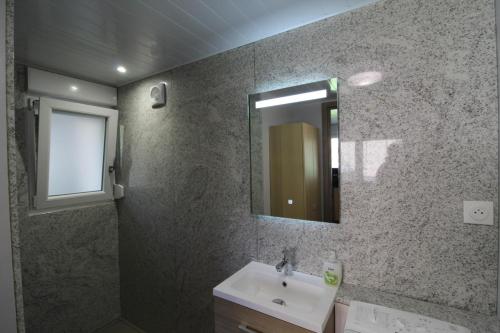 une salle de bain avec un lavabo et un miroir dans l'établissement Gîte à Rufus, Maison de charme au Ménil, au cœur de la nature vosgienne, à Le Ménil