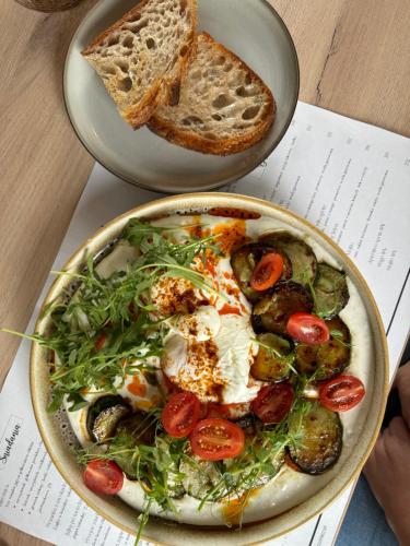a bowl of food with vegetables and bread on a table at Milo Aparthotel in Wrocław