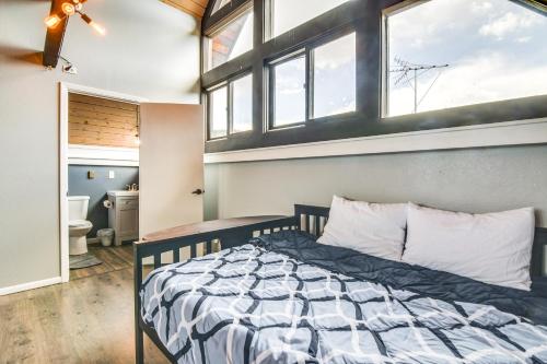a bedroom with a bed in a room with windows at 5 Mi to Dtwn Evergreen Mtn-View Escape in Evergreen