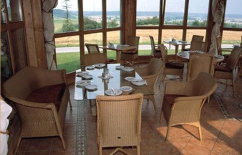a restaurant with tables and chairs and a large window at Hotel Bergwirt in Herrieden