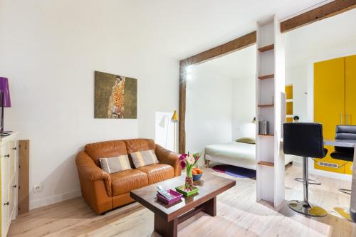 un salon avec un canapé et une table dans l'établissement Studio Montonnerre avec terrasse proche Necker et Montparnasse, à Paris