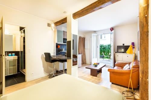 une chambre avec un lit et un salon dans l'établissement Studio Montonnerre avec terrasse proche Necker et Montparnasse, à Paris