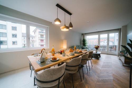 une grande salle à manger avec une longue table et des chaises dans l'établissement L'Écrin Annécien by ExplorHome, à Annecy