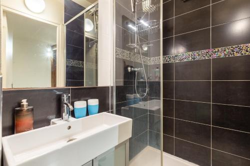 une salle de bain avec un lavabo et une douche dans l'établissement Studio Montonnerre avec terrasse proche Necker et Montparnasse, à Paris