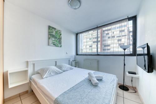 une petite chambre avec un lit et une fenêtre dans l'établissement Charming Flat in Villeurbanne Gratte-Ciel, à Villeurbanne