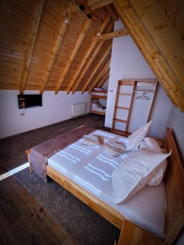 a large bed in a room with a wooden ceiling at Alpin Chalet in Rucăr
