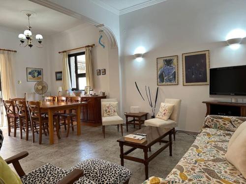 a living room with a table and a dining room at Kato Panayia Cafe Retreat in Káto Panayía