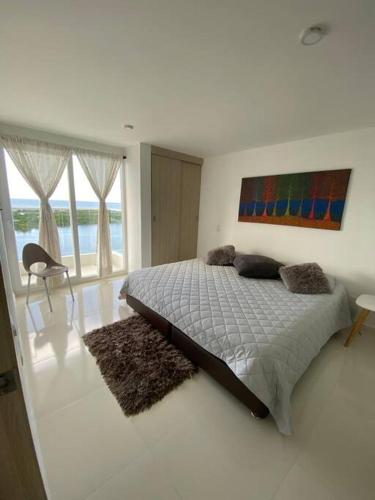 a bedroom with a bed and a painting on the wall at Mirador del Mar Playa Mendoza in Tubará