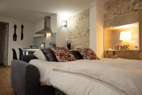 une chambre avec un lit, un canapé et un miroir dans l'établissement Duplex LE STUD'71 - 100m de la gare, à Chalon-sur-Saône