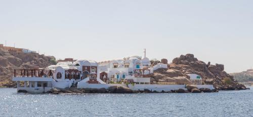 a group of white buildings sitting on the water at Aro Kato Nubian Guest House in Aswan