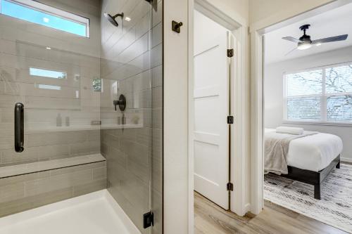 ein Badezimmer mit ebenerdiger Dusche neben einem Bett in der Unterkunft El Paso Executive Suites - Pet Friendly NEW BUILD in Colorado Springs