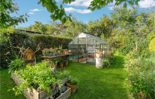 a garden with a greenhouse and some plants at Awesome Home In Føllenslev With Wifi in Føllenslev