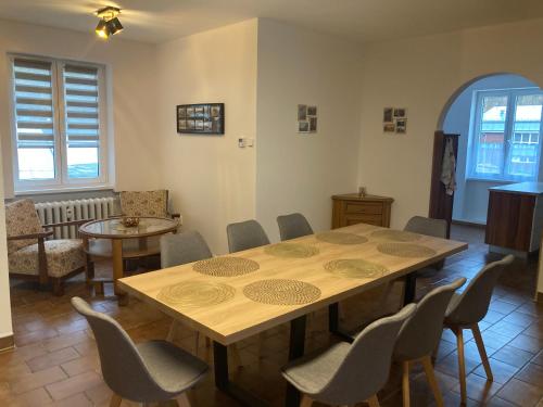 a dining room with a wooden table and chairs at Apartmán Monika in Kraslice