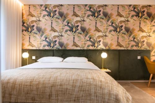 una camera da letto con un letto grande con carta da parati floreale di Savannah Apartment, by Bolhão Residences a Porto