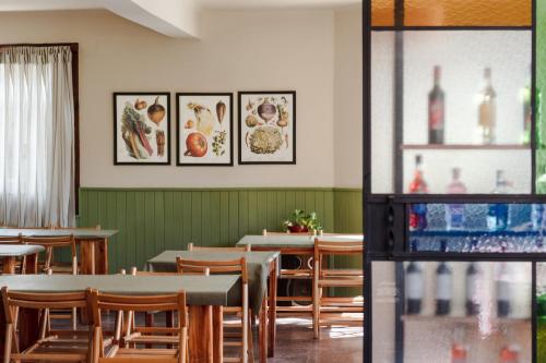 a restaurant with tables and chairs and pictures on the wall at Hotel Turismo in San Martín de los Andes