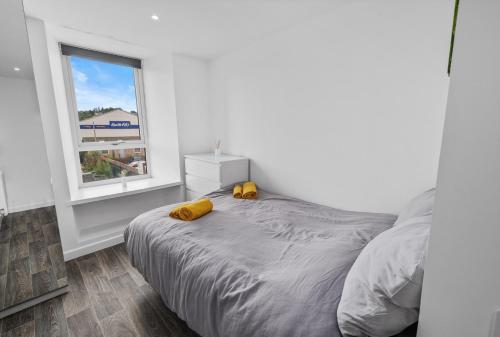 a bedroom with a bed with two yellow pillows on it at Cosy & Comfortable 2BR in Oban - Walk to Waterfront in Oban