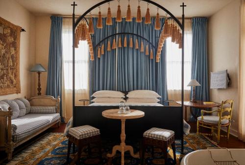 a bedroom with a bed and a table and a couch at Hotel Peter and Paul, an Ash Hotel in New Orleans