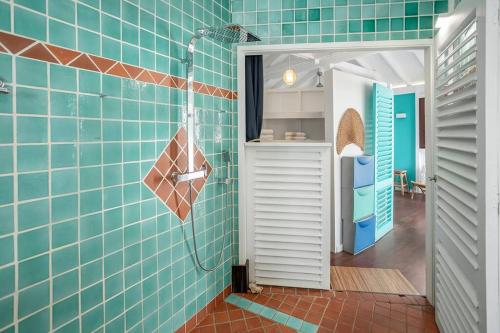 a bathroom with blue tiles and a shower at Le Spot - Unique house with view in Oyster Pond