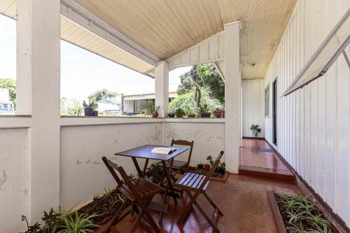 a porch with a table and chairs on it at Memora Guesthouse Curitiba - Quartos em Casa próximo ao Parque Bacacheri in Curitiba