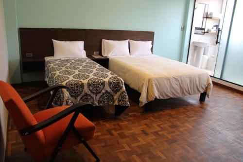 a hotel room with a bed and a chair at Kunan Hotel in Cochabamba
