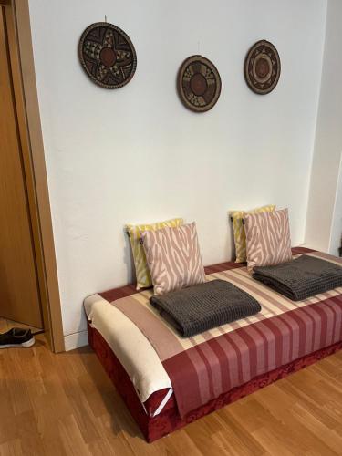 a bed in a room with two plates on the wall at Apartamento Plauen in Plauen