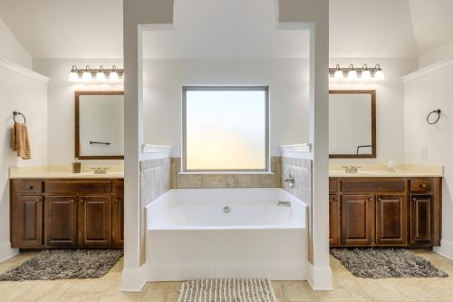 baño con bañera blanca y 2 espejos en 8 Mi to Trilith Studios Home with Fire Pit!, en Fayetteville