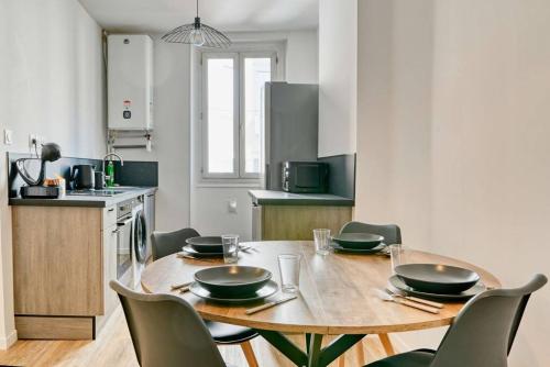- une cuisine avec une table et des chaises en bois dans l'établissement Sublime Appartement 3 chambres, à Marseille
