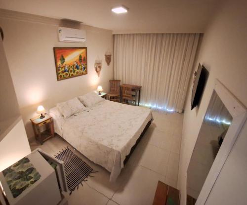 a bedroom with a bed and a table and chairs at Suítes Cambucá in Ilhabela