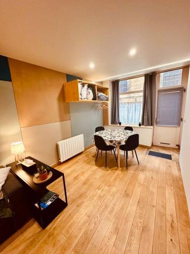 un salon avec une table et des chaises dans une pièce dans l'établissement Studio Le Franc Bourgeois, à Sedan