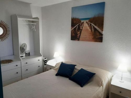 une chambre avec un lit avec deux oreillers bleus dans l'établissement Appartement Saint Pierre la Mer 4 personnes, vue sur la mer, piscine, parking, tennis N366, à Saint Pierre La Mer