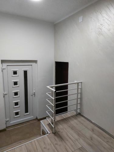 Habitación vacía con puerta y suelo de madera en R Apartments, en Paraćin