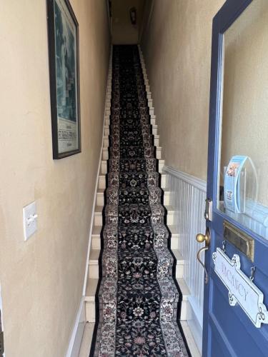 a hallway with stairs with a tile floor and a blue door at Spring Street Overlook in Eureka Springs