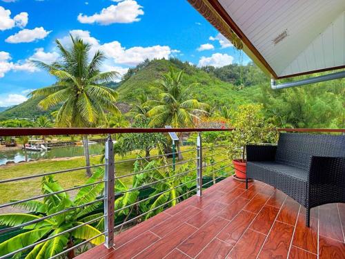 a balcony with two chairs and a view of a mountain at Free canoës King Bed - Fare Vaihere in Moorea