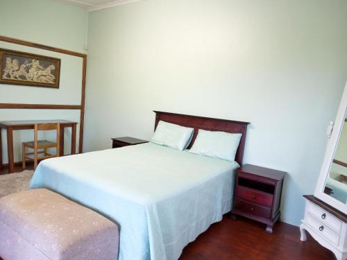 a bedroom with a bed and a table and a chair at 83 Ocean View in Port Shepstone