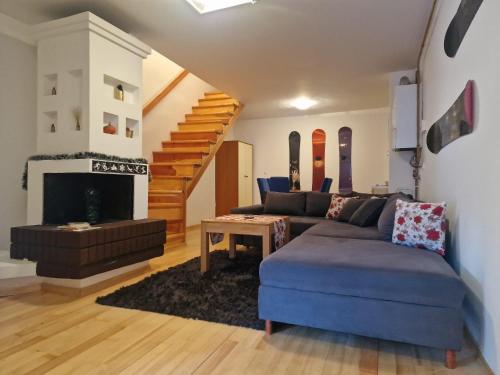 a living room with a couch and a fireplace at BJELAŠNICA BEX APARTMANI in Bjelašnica