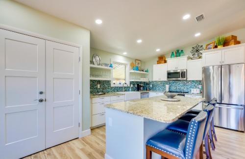 a kitchen with white cabinets and a counter with blue chairs at Waterfront Home with Boat Dock and Slip in Old Town! in Old Town