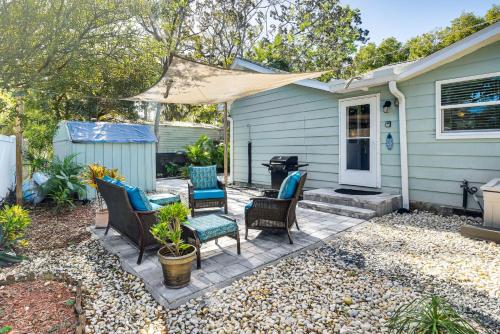 a patio with chairs and a grill in front of a house at Dog-Friendly Daytona Beach Cottage with Patio! in Daytona Beach