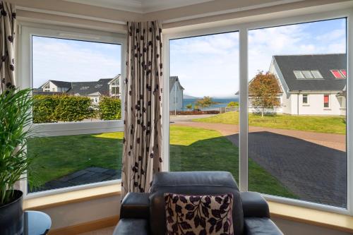 a living room with a couch and a large window at Stunning Sea Views - Luxury 4BR Beach House in Oban