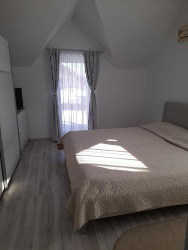 a bedroom with a bed and a window at Apartament CASA MIRIAM in Lugoj