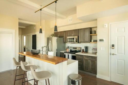 a kitchen with a counter and some chairs in it at Downtown, contemporary, 2 bedroom, Roof Terrace! 4A in Savannah