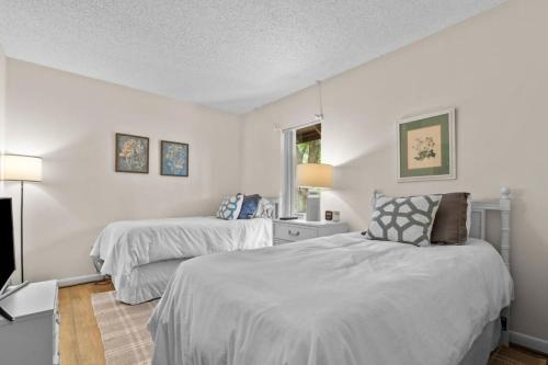 two beds in a room with white walls at Pinehurst Choice in Pinehurst