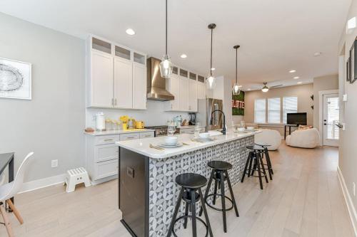 a kitchen with white cabinets and bar stools at On the Move in Plaza Midwood in Charlotte
